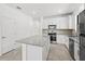 Bright kitchen with a granite-topped island, stainless steel appliances, and tiled flooring at 1975 Pepper Grass Dr, North Port, FL 34289