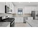Stylish kitchen with stainless steel appliances, modern cabinetry, granite countertops, and center island at 1975 Pepper Grass Dr, North Port, FL 34289