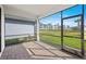 Screened-in patio with brick floor and view of the spacious backyard and blue sky at 1975 Pepper Grass Dr, North Port, FL 34289