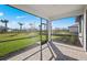 Covered patio with brick flooring overlooks the spacious landscaped backyard with palm trees at 1975 Pepper Grass Dr, North Port, FL 34289
