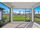 Covered patio overlooks the landscaped yard with palm trees and lush greenery at 1975 Pepper Grass Dr, North Port, FL 34289