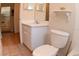 Bathroom featuring a vanity, toilet, and neutral tile flooring, with the kitchen partially visible at 35324 Whispering Pines Dr, Zephyrhills, FL 33541