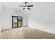 Bright bedroom with ceiling fan, wood-look tile flooring and sliding glass door to the outside at 4743 Michaler St, North Port, FL 34286