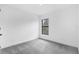 Bright bedroom featuring plush gray carpeting, white walls, and a window to the outside at 4743 Michaler St, North Port, FL 34286