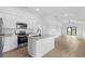 Bright, open kitchen featuring white cabinets, stainless steel appliances and a kitchen island at 4743 Michaler St, North Port, FL 34286