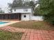 View of the home and backyard with pool, porch, and fenced yard at 6919 Greenhill Pl, Tampa, FL 33617