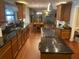 A spacious kitchen featuring black granite countertops and dark wood cabinets, flowing into the dining and living areas at 6919 Greenhill Pl, Tampa, FL 33617