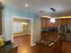 Open kitchen with stainless steel appliances, double ovens, tile backsplash, and center island with cooktop at 6919 Greenhill Pl, Tampa, FL 33617