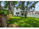 Expansive backyard with a well-kept lawn, privacy fence, and mature trees, ideal for outdoor activities at 1046 Bass Blvd, Dunedin, FL 34698