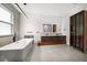 Bright and contemporary bathroom with a freestanding tub, double vanity, and stylish display cabinet at 1046 Bass Blvd, Dunedin, FL 34698
