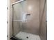 Modern shower with glass doors, tile walls, shower niche, and a unique tile floor pattern at 1046 Bass Blvd, Dunedin, FL 34698