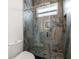 Elegant bathroom featuring marble-like tile in the shower, glass door, and hexagon tile flooring at 1046 Bass Blvd, Dunedin, FL 34698