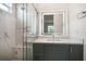 Contemporary bathroom with a glass shower, illuminated mirror, and gray vanity, showcasing modern design at 1046 Bass Blvd, Dunedin, FL 34698