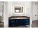 Modern bathroom with a stylish blue vanity, lighted mirror, and sleek fixtures, offering contemporary elegance at 1046 Bass Blvd, Dunedin, FL 34698