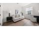 Bright bedroom featuring a comfortable sofa, side tables with lamps, desk, and hardwood floors at 1046 Bass Blvd, Dunedin, FL 34698