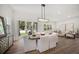 Bright dining area with modern chandelier, table with seating, and sliding glass door to the backyard at 1046 Bass Blvd, Dunedin, FL 34698