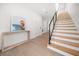 Bright entryway featuring light wood floors, a staircase with black metal railings, and a console table at 1046 Bass Blvd, Dunedin, FL 34698