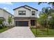 Stunning two-story home with modern design, brick accents, a paved driveway and well-maintained landscaping at 1046 Bass Blvd, Dunedin, FL 34698