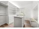 Spacious walk-in closet with custom shelving, drawers, and a built-in vanity area for added convenience and style at 1046 Bass Blvd, Dunedin, FL 34698