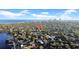 Overhead view of a neighborhood showcasing rooftops and lush greenery with city skyline visible in the distance at 216 21St Ne Ave, St Petersburg, FL 33704