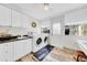 Bright laundry room with modern appliances, sleek cabinets, and a door leading to the exterior at 216 21St Ne Ave, St Petersburg, FL 33704