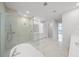 Bright bathroom featuring a glass shower, a free-standing tub, and marble floors at 2910 W Barcelona St # Ph-2303, Tampa, FL 33629