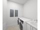 Laundry room with a new white washer and dryer, sink and grey cabinets at 2910 W Barcelona St # Ph-2303, Tampa, FL 33629