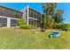Back exterior view of the home featuring a screen porch, fire pit, landscaping, and a kayak at 6320 Grand Bahama Cir # 6320, Tampa, FL 33615