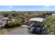 Aerial view of boat dock and lift in a canal community with lush green trees and landscaping at 6320 Grand Bahama Cir # 6320, Tampa, FL 33615
