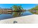 Picturesque view of private dock on canal with screen-enclosed patios and tropical landscaping at 6320 Grand Bahama Cir # 6320, Tampa, FL 33615