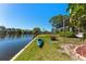 Waterfront view of the home with lush landscaping, kayak, and a fire pit at 6320 Grand Bahama Cir # 6320, Tampa, FL 33615