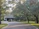 View of home with garage. The property is surrounded by mature trees, with a circular driveway at 103 Old Mill Pond Rd, Palm Harbor, FL 34683