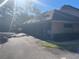 Exterior view showing the garage and asphalt driveway, surrounded by trees and greenery, providing shade at 103 Old Mill Pond Rd, Palm Harbor, FL 34683