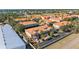 Aerial view of residences with tile roofs, palm trees, parking spaces, and landscaping at 1264 Riserva Ln, Palm Harbor, FL 34683