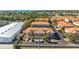 Aerial view of a property with tile roofs, palm trees, and parking spaces at 1264 Riserva Ln, Palm Harbor, FL 34683