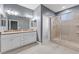 Bathroom with dual sinks, white cabinets, and a glass shower door at 1264 Riserva Ln, Palm Harbor, FL 34683