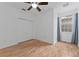 Bright bedroom with hardwood floors, white walls, ceiling fan, and window with blue drapes at 1264 Riserva Ln, Palm Harbor, FL 34683
