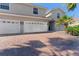 Inviting home with brick driveway, three-car garage, and well-maintained landscaping at 1264 Riserva Ln, Palm Harbor, FL 34683