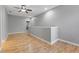 Spacious loft area with hardwood floors and gray walls and ceiling fan at 1264 Riserva Ln, Palm Harbor, FL 34683