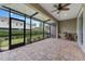 Screened patio with brick flooring, ceiling fan, seating and outdoor view at 1264 Riserva Ln, Palm Harbor, FL 34683