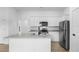 Modern kitchen featuring an island, granite countertops, and stainless steel appliances at 5402 Ojus St, North Port, FL 34286