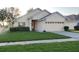 Well-maintained home featuring a lush green lawn, clean sidewalk, and a spacious two-car garage at 9551 Jaybird Ln, Land O Lakes, FL 34638