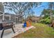 Backyard featuring a playhouse, grill and adjacent to the screened in pool area at 1753 Lucas Dr, Clearwater, FL 33759