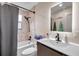 Modern bathroom featuring a shower over tub and single vanity with black hardware at 1753 Lucas Dr, Clearwater, FL 33759