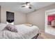 Bedroom with neutral decor, a ceiling fan and pink room in the background at 1753 Lucas Dr, Clearwater, FL 33759