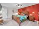 Stylish bedroom features a ceiling fan, and wood furnishings that complement the red accent wall at 1753 Lucas Dr, Clearwater, FL 33759