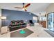 Comfortable living room with black leather seating, a ceiling fan, and access to the dining area at 1753 Lucas Dr, Clearwater, FL 33759