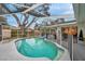 Screened-in pool with an inflatable raft, surrounded by a safety fence at 1753 Lucas Dr, Clearwater, FL 33759