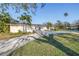 Well-maintained single-Gathering home with a lush green lawn, palm trees, and spacious driveway at 3075 Rosery Ne Rd, Largo, FL 33771