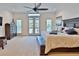 Spacious main bedroom features a ceiling fan, plush carpet, and access to a private balcony at 3222 W Empedrado St, Tampa, FL 33629
